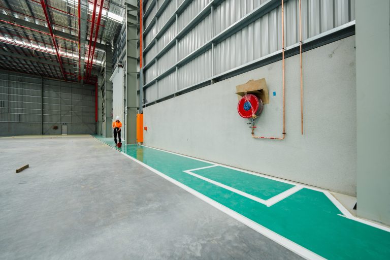 Green epoxy walkway between concrete floor areas in a warehouse